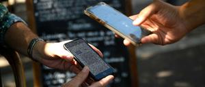 Auf der Terrasse eines Cafés in Marseille überprüft ein Kellner einen Gesundheitspass.