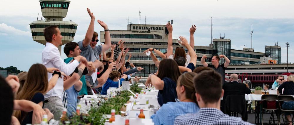 Teilnehmer am "Freedom Dinner" sitzen an Tischen auf der Landebahn des ehemaligen Flughafen Tegel.