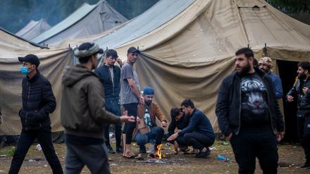 Migranten bereiten in einem neu errichteten Flüchtlingslager auf dem Truppenübungsplatz Rudninkai Essen zu. 