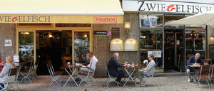 Außenansicht der Kneipe Zwiebelfisch mit Schankvorgarten am Savignyplatz in Berlin-Charlottenburg.