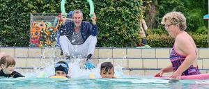 Damit keiner untergeht. Ulrich Matthes mit Schwimmschülern und deren Betreuerin Astrid Bär.