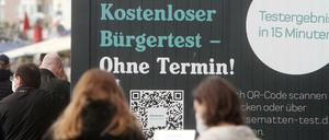 Menschen warten in Düsseldorf vor einem Testzentrum.