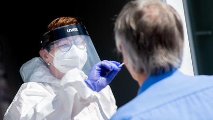 Eine Testcenter-Mitarbeiterin in Norddeich nimmt einen Abstrich.