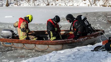  Einsatzkräfte der Feuerwehr bereiten sich auf den Einsatz im Karpfenteich im Treptower Park vor.