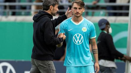 Ein Spieler zu viel Wolfsburgs Trainer Mark van Bommel (l) steht vor der Einwechslung mit Maximilian Philipp zusammen. 
