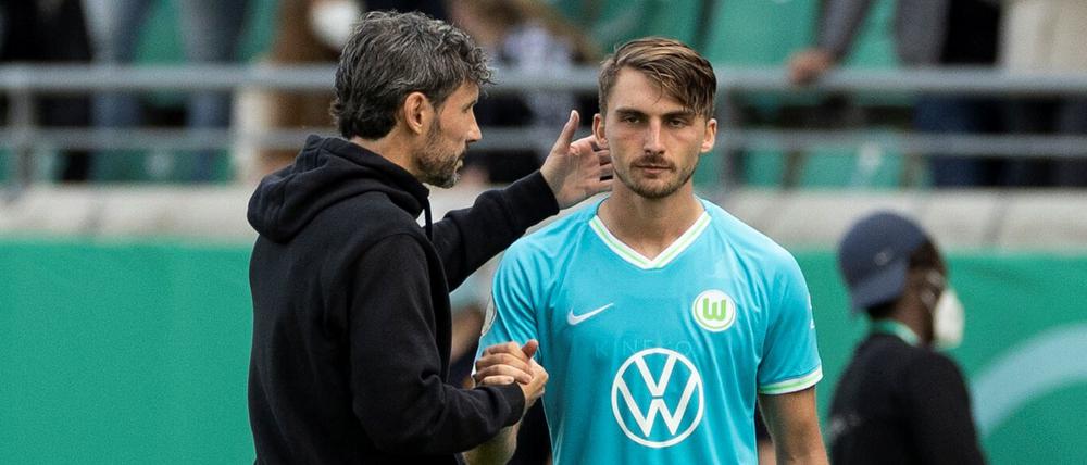 Ein Spieler zu viel Wolfsburgs Trainer Mark van Bommel (l) steht vor der Einwechslung mit Maximilian Philipp zusammen. 