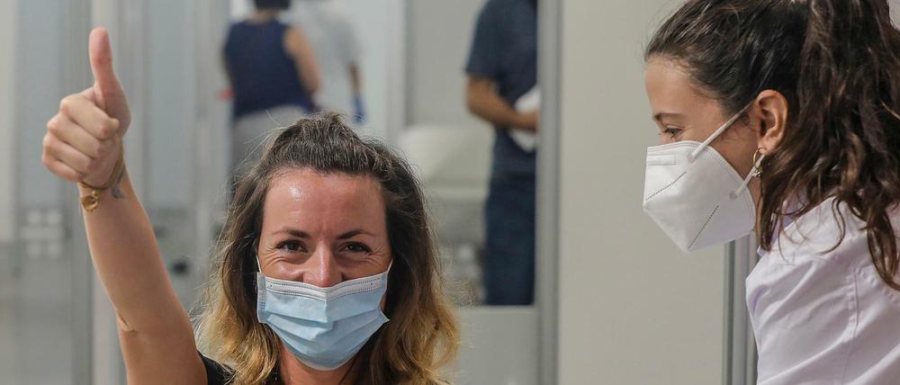Eine junge Frau hebt in Valencia, Spanien, den Daumen, nachdem sie gegen das Coronavirus geimpft wurde.