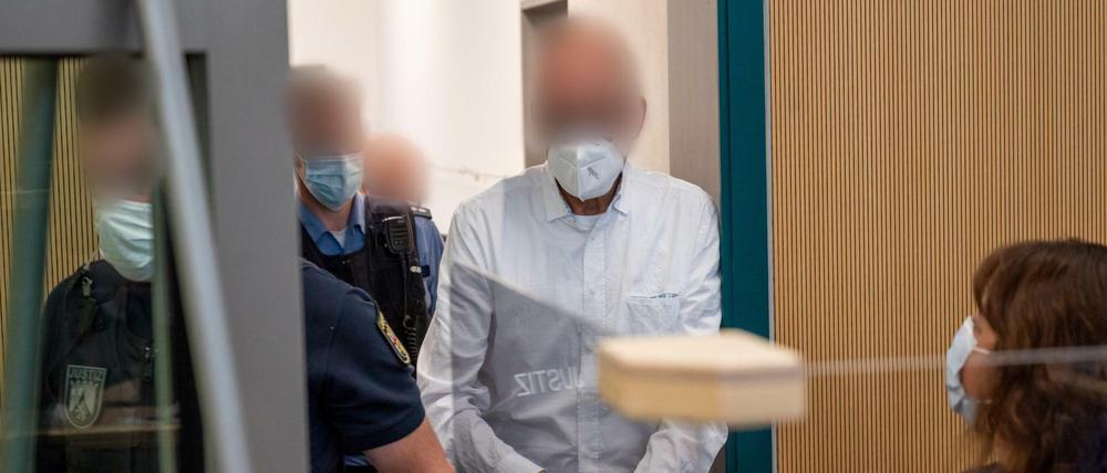 Der Angeklagte (2.v.r) wird in den Gerichtssaal im Landgericht Trier geführt, vorn rechts seine Verteidigerin Martha Schwiering. 