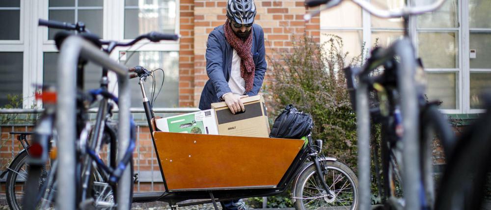 Ein Mann belädt ein Lastenrad in Berlin.