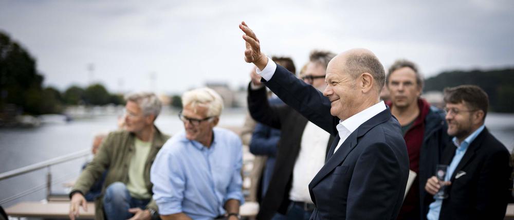 SPD-Kanzlerkandidat winkt auf der Havel Ruderern zu, die ihn grüßen.