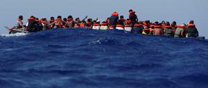 Auf lebensgefährlichen Wogen. Flüchtlinge auf einem Holzboot vor Lampedusa warten auf die Rettung durch die deutsche Sea-Watch und die italienische Küstenwache. 