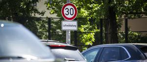 Ein Verkehrsschild zur Vorgabe der maximalen Geschwindigkeit auf 30 km/h hängt über dem Schild Luftreinhaltung auf der Leipziger Straße in Berlin.
