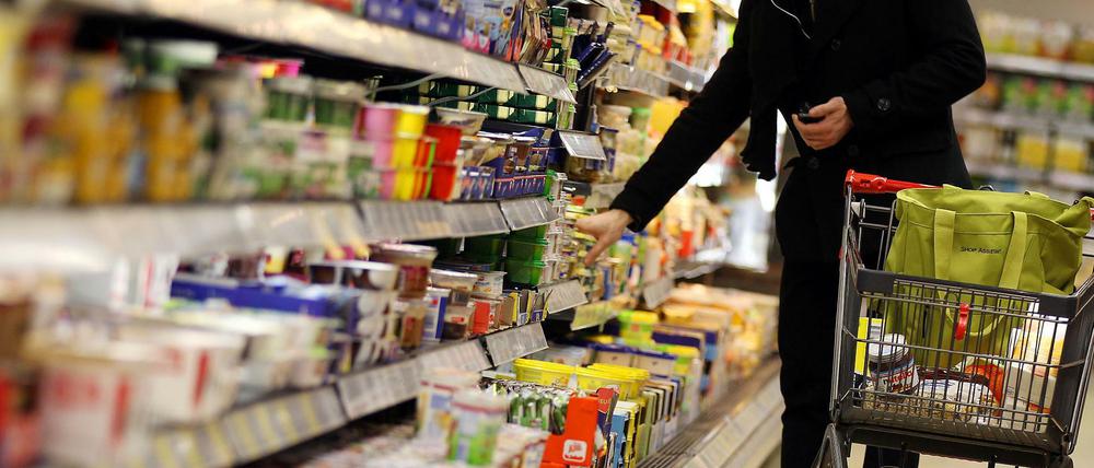 Ein Kunde steht am in Köln (Nordrhein-Westfalen) vor einem Supermarktregal.