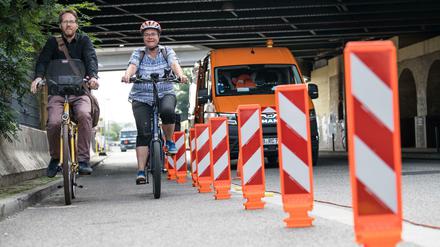 Unterwegs für die Verkehrswende in Friedrichshain-Kreuzberg: Bezirksstadtrat Florian Schmidt (l.) und Bezirksbürgermeisterin Monika Herrmann (beide Bündnis 90/Die Grünen). Auf dem Bild begutachten sie die Montage der so genannten Leitboys auf dem Radfahrstreifen in der Tamara-Danz-Straße. 