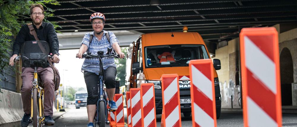 Unterwegs für die Verkehrswende in Friedrichshain-Kreuzberg: Bezirksstadtrat Florian Schmidt (l.) und Bezirksbürgermeisterin Monika Herrmann (beide Bündnis 90/Die Grünen). Auf dem Bild begutachten sie die Montage der so genannten Leitboys auf dem Radfahrstreifen in der Tamara-Danz-Straße. 
