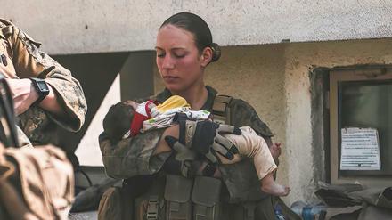 In diesem Bild vom 20. August 2021, das vom US Marine Corps zur Verfügung gestellt wurde, beruhigt Nicole Gee ein Baby in Kabul.