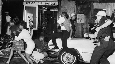 Auf der Flucht: Ein Polizist jagt Bewohnerinnen und Bewohner Harlems am 20. Juli 1964. 