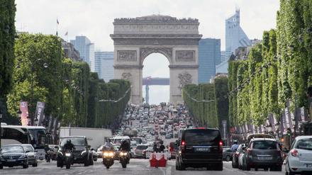 Autos fahren über die Champs-Elysees unweit des Arc de Triomphe in Paris. Seit Montag nur noch mit Tempo 30.