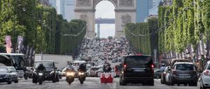 Autos fahren über die Champs-Elysees unweit des Arc de Triomphe in Paris. Seit Montag nur noch mit Tempo 30.