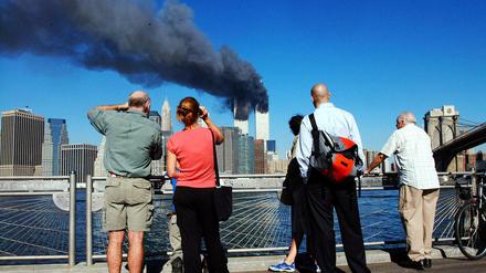 Ein unwirklich blauer Himmel und ein unwirklich furchtbares Ereignis. Fußgänger in Brooklyn schauen nach Manhattan. 