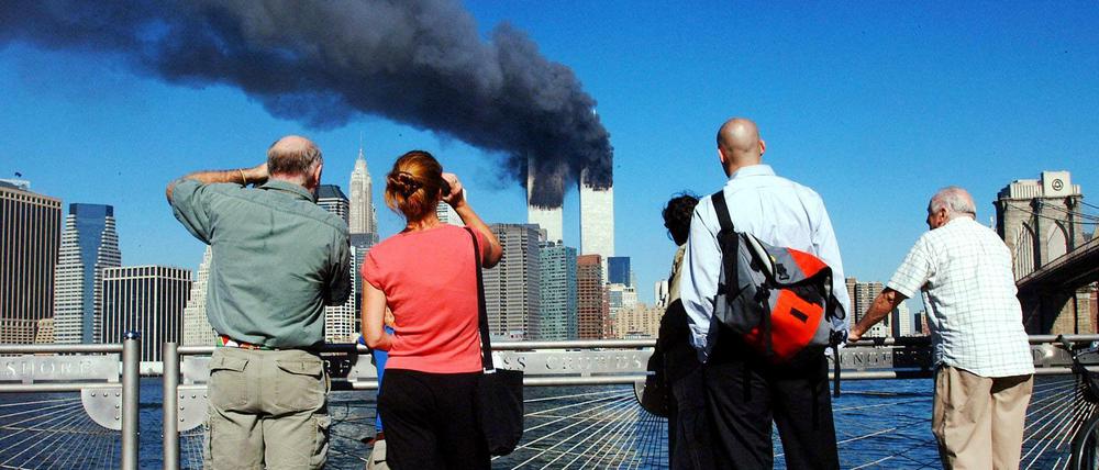 Ein unwirklich blauer Himmel und ein unwirklich furchtbares Ereignis. Fußgänger in Brooklyn schauen nach Manhattan.
