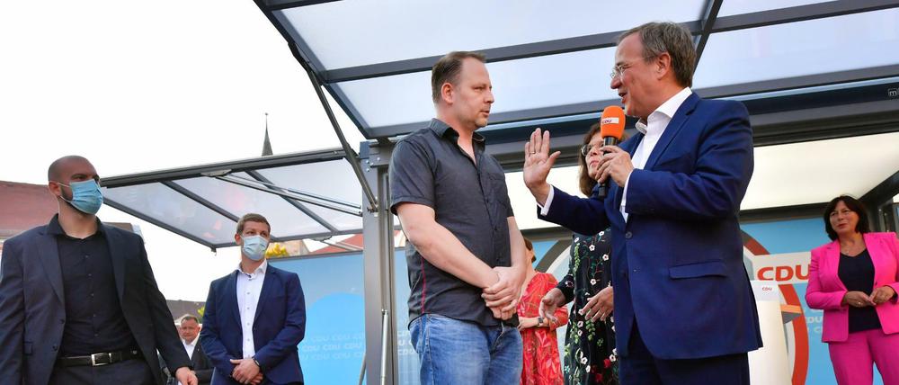 Armin Laschet unterhält sich mit dem Mann, der einfach maskenlos auf die Bühne ging.
