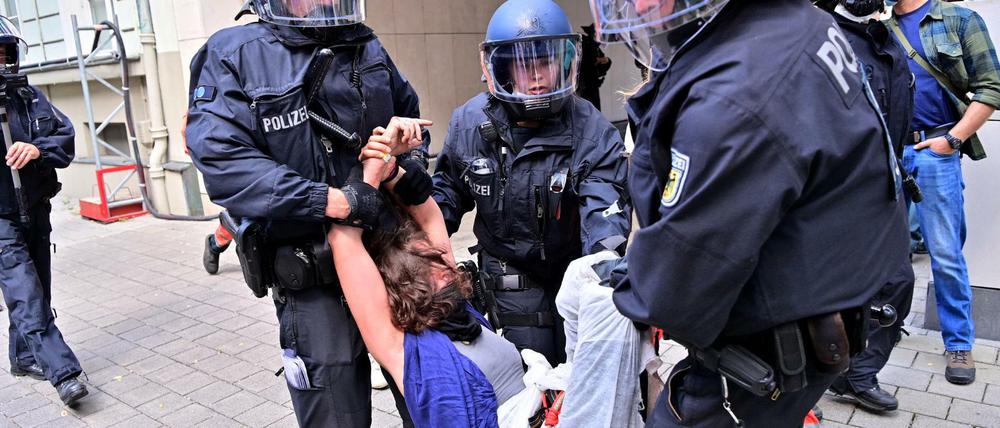 Eine Protestteilnehmerin wird während einer Demonstration gegen die Automesse IAA-Mobility von Polizisten weggetragen.