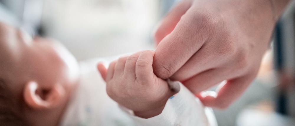 Ein Baby klammert sich an den Finger seiner Mutter. (Symbolbild)