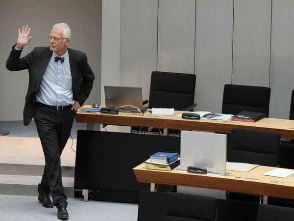 Jürgen Zöllner verlässt seinen Platz im Abgeordnetenhaus und winkt mit der rechten Hand.