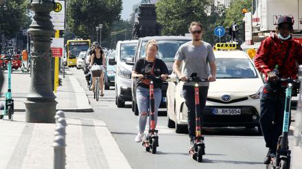 Busse, Autos, E-Scooter auf der Straße Unter den Linden.