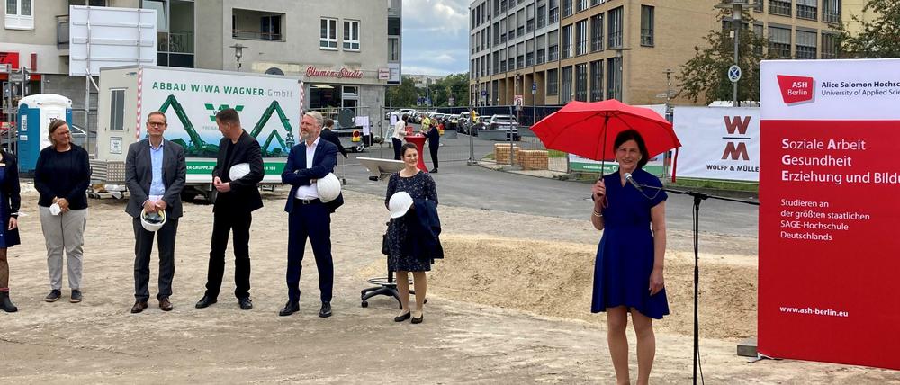 Hochschulleitung und Politiker haben sich auf einer Baustelle zum Gruppenfoto aufgestellt.