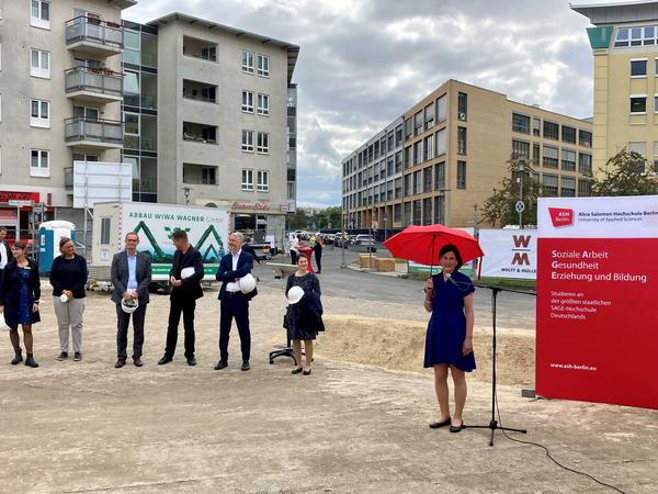 Hochschulleitung und Politiker haben sich auf einer Baustelle zum Gruppenfoto aufgestellt.