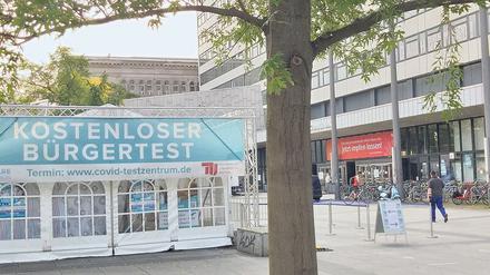 Vor dem Hauptgebäude der TU Berlin steht ein Testzelt, über der Eingangstür hängt ein Banner mit der Aufforderung "Jetzt impfen lassen!".