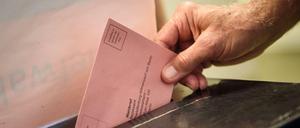 Ein Wähler wirft seinen ausgefüllten Wahlzettel in einem Wahllokal im Berliner Bezirk Charlottenburg-Wilmersdorf in eine Wahlurne. (Archivbild)