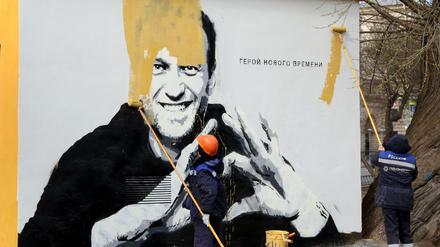 Städtische Arbeiter übermalen in St. Petersburg ein Bild des russischen Oppositionsführers Alexej Nawalny. 