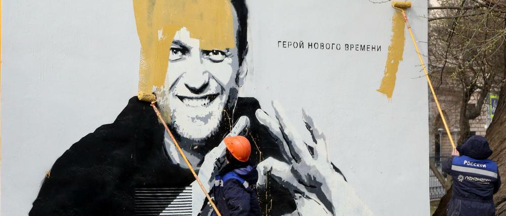 Städtische Arbeiter übermalen in St. Petersburg ein Bild des russischen Oppositionsführers Alexej Nawalny.