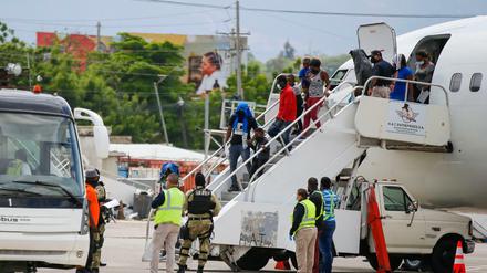 Haitianer, die aus den USA abgeschoben wurden, steigen am internationalen Flughafen Toussaint Louverture aus einem Flugzeug.