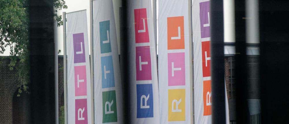Fahnen des Fernsehsenders RTL stehen auf dem Platz vor dem Firmengebäude.