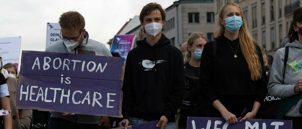 Teilnehmer und Teilnehmerinnen an der Gegendemonstration zum "Marsch für das Leben" stehen mit Plakaten auf dem Pariser Platz.