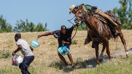 Ein US-Grenzschützer greift nach einen Migranten aus Haiti. 