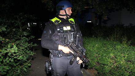 Schwer bewaffnete Beamte sichern den Tatort ab.