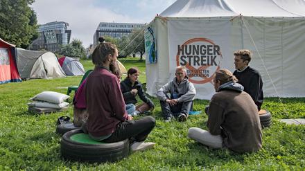 Umweltaktivisten sitzen vor einem Zelt in einem Camp in der Nähe des Reichstags. 