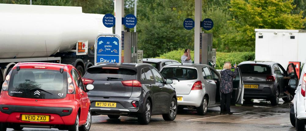 Fahrzeuge, stehen in einer Warteschlange an einer Tankstelle.