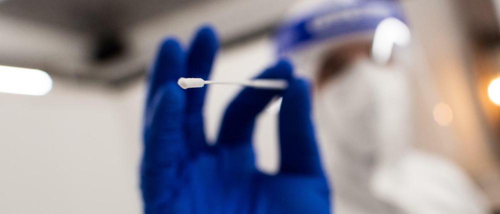 Ein Mitarbeiter des Covid 19-Schnelltest-Zentrums Düsseldorf nimmt bei einem Patienten eine Probe für einen Schnelltest.