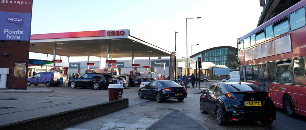 Autofahrer stehen an einer Tankstelle in einer Schlange, um zu tanken.