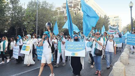 Jüdische und arabische Frauen protestieren mit einem Demozug durch eine Straße in Jerusalem für den Frieden.