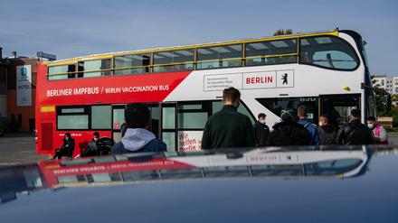 Menschen stehen auf dem Gelände des Dong Xuan Centers vor dem ersten Berliner Impfbus, um sich gegen Corona impfen zu lassen.