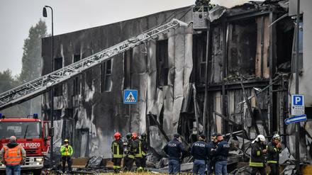 Feuerwehrleute und Polizisten stehen an der Unfallstelle.