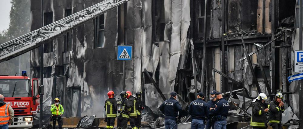 Feuerwehrleute und Polizisten stehen an der Unfallstelle.