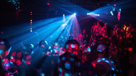 Menschen feiern im Club in Berlin. 